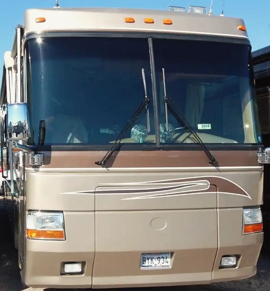 The same motorhome after repair, with a new windshield and the front cap rebuilt and painted