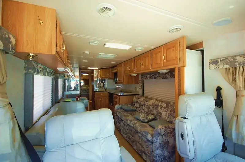 Motorhome lounge before the remodel, with oak cabinets and patterned sofa